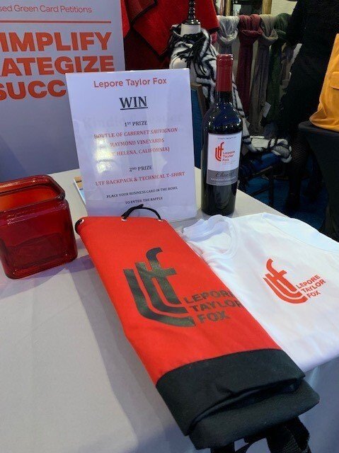 Wine, a backpack, and a t-shirt on a table available as a prize.