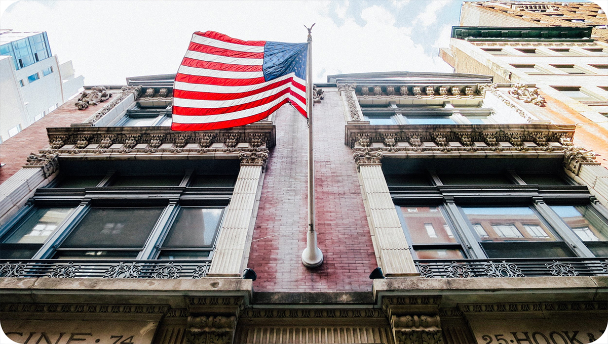 American flag flying from a brick building.